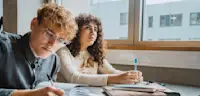 Young multiracial male and female students learning in classroom at community college